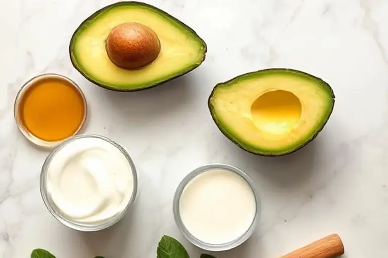 Smoothie ingredients including ripe avocado, honey, and yogurt on a table